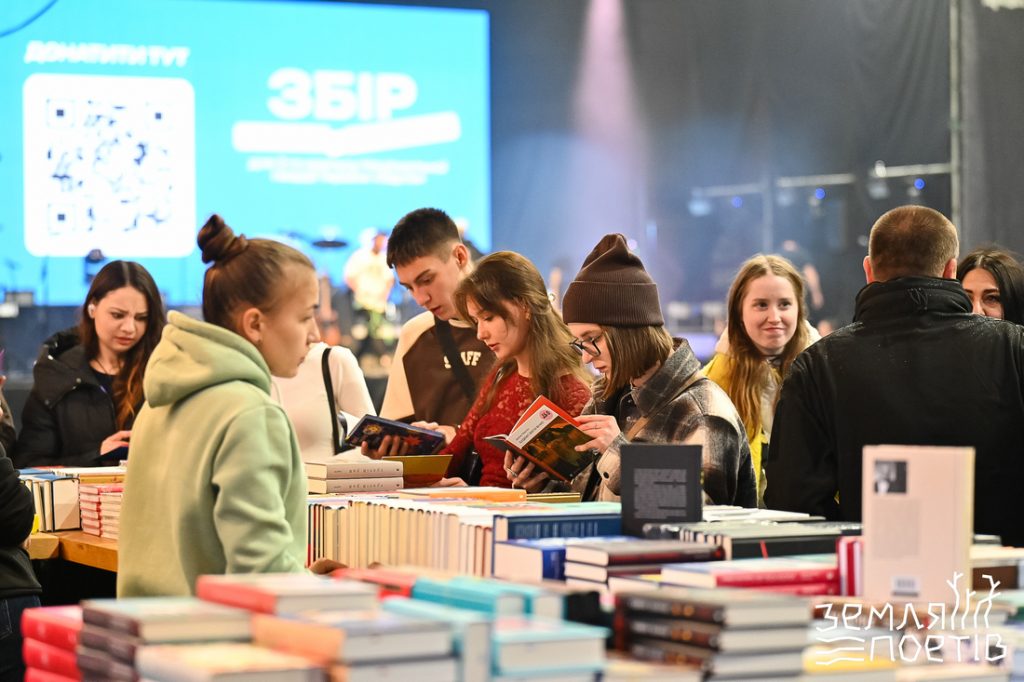 символічна сцена фестивалю з мікрофоном, відкритими поетичними книжками та осінніми листями
