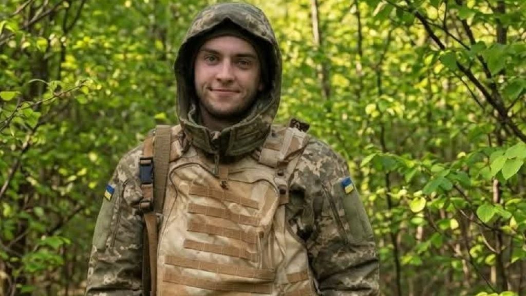 символічна композиція: вивіска вулиці, свічка та жетон українського бійця