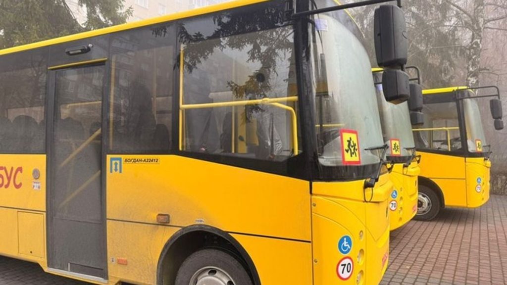 порожні шкільні автобуси біля каністр з паливом на сільському тлі