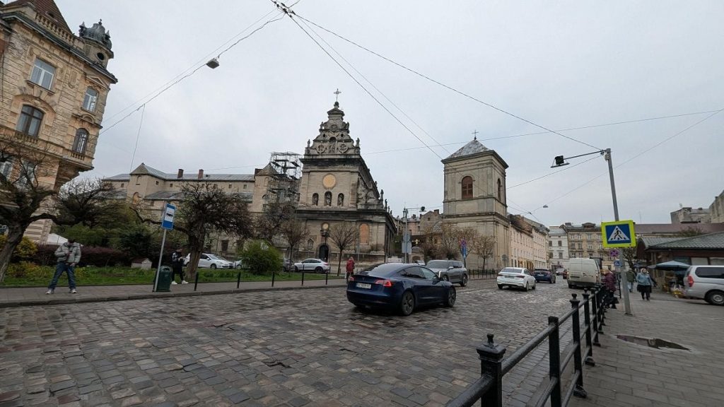Крупний план вікна з краплями дощу, осіннє листя на підвіконні й невеликий термометр