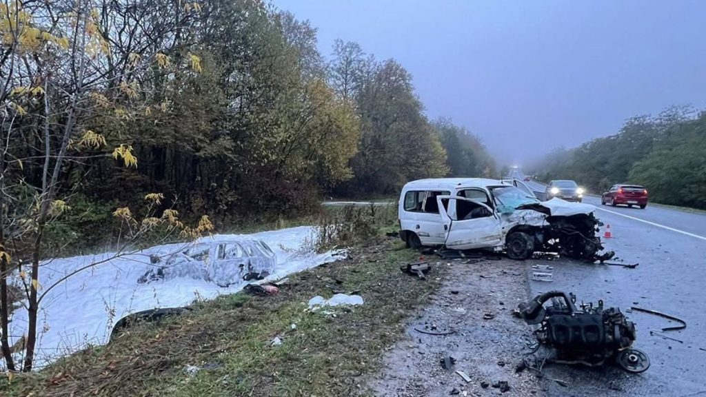 символічна сцена зі зруйнованими автомобілями на сільській дорозі, габаритні вогні та медичне обладнання, без облич