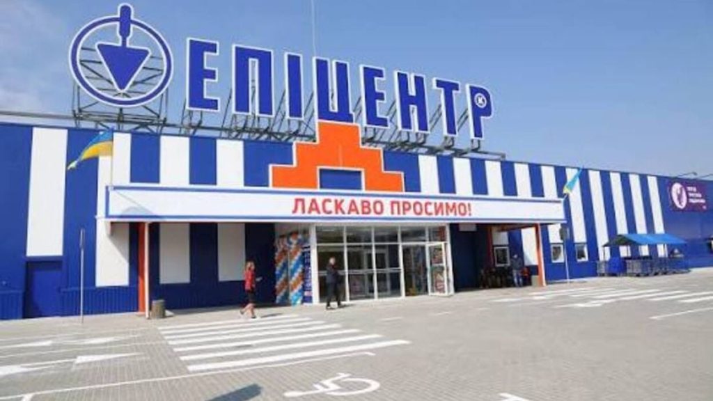 символічна сцена пошкодженого входу до торговельного центру з димом і уламками