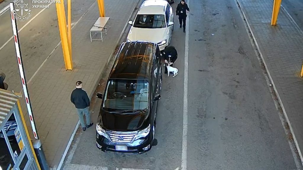 вакуумні пакети на столі поруч із ключем від авто та розмитим знаком митного переходу