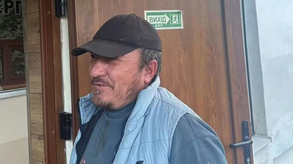 складена синя жилетка з невидимим логотипом на дерев'яній лавці поруч сільської дороги