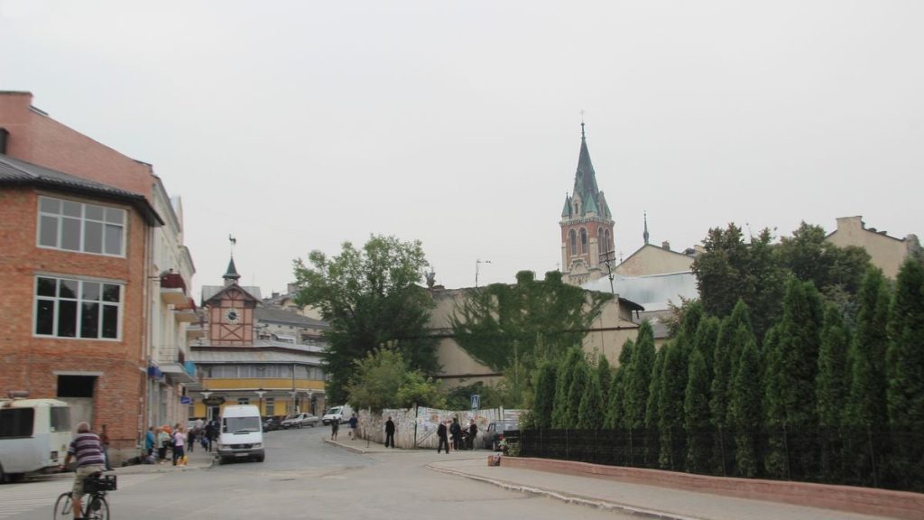 фрагмент дрона та шкільний рюкзак на тротуарі на тлі світла аварійних служб
