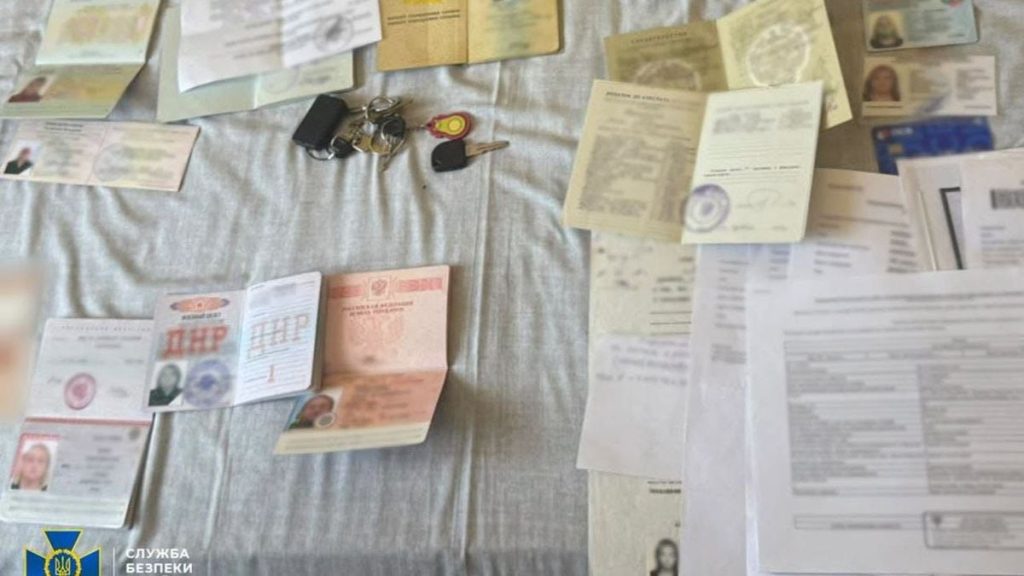 символічна сцена з ключем від готелю, паспортом і військовим квитком на дерев'яному столі
