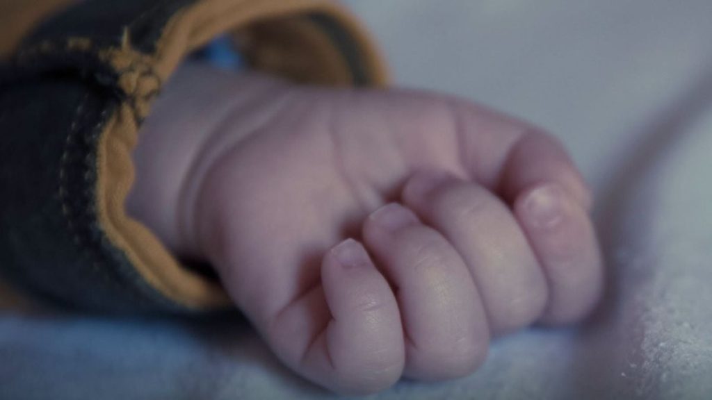 дитячі черевички поруч із ковдрою та паперами