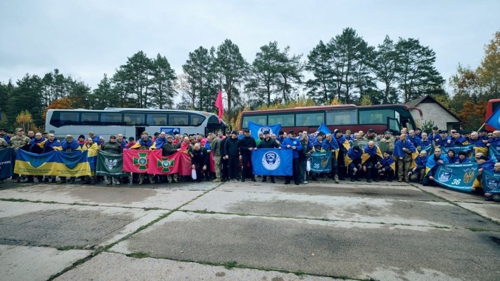 символічна сцена: розкладений військовий одяг і маленький прапор України на лавці