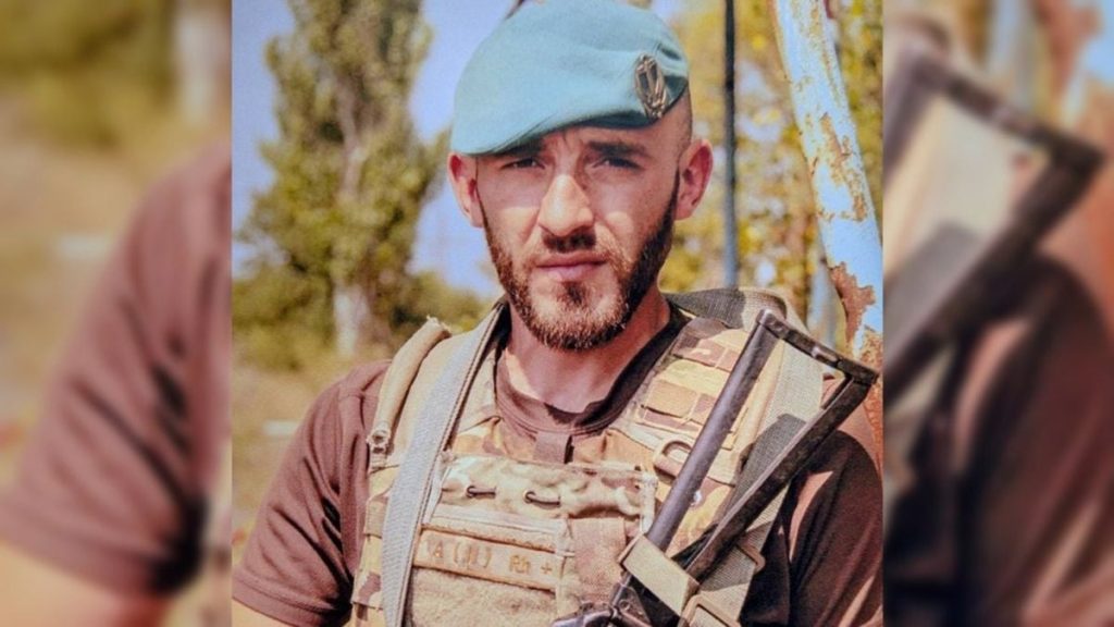 зіношені військові черевики і складений рукописний лист на дерев'яному столі