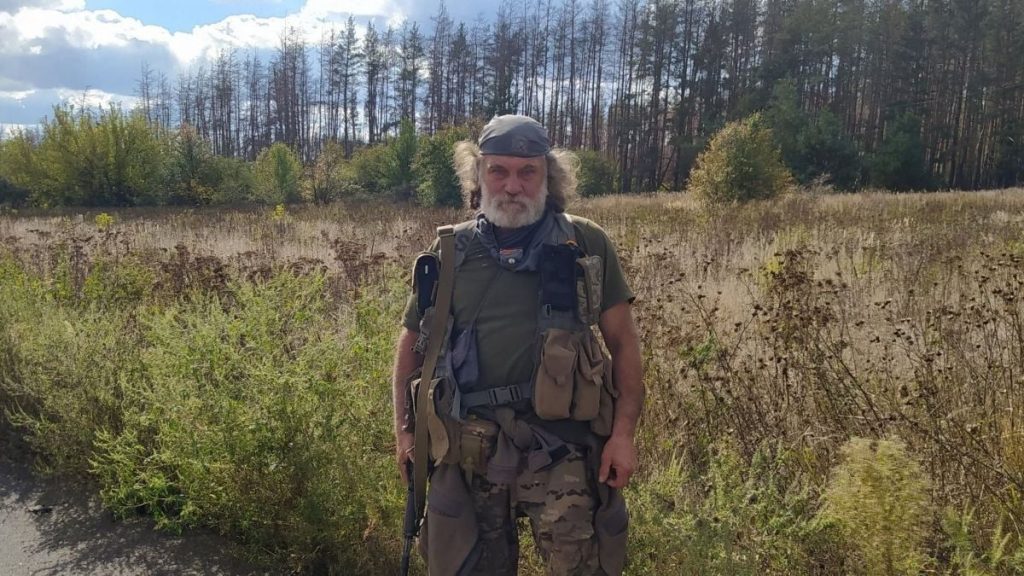 зношений туристичний черевик поруч із картою та мотузкою на дерев'яному столі