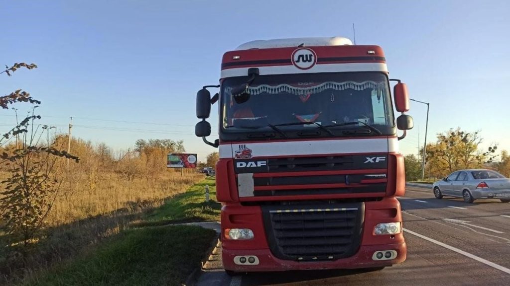 символічна сцена: мотоцикл і вантажівка на порожній сільській дорозі в сутінках, без облич