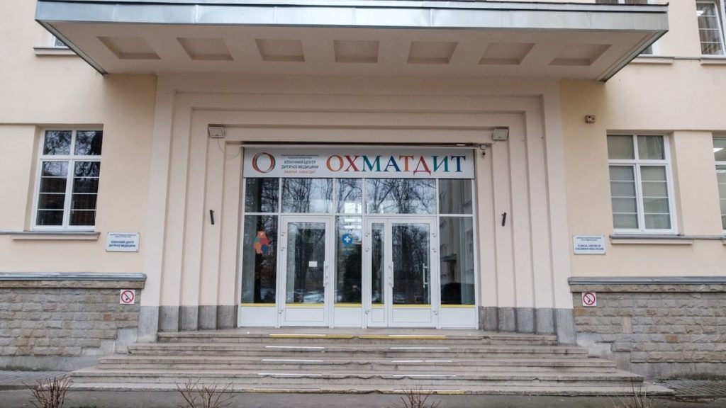 Мінімалістична сцена операційної: монітор із зображеннями мозку та навігаційними шарами, візок із колесами, стерильні інструменти