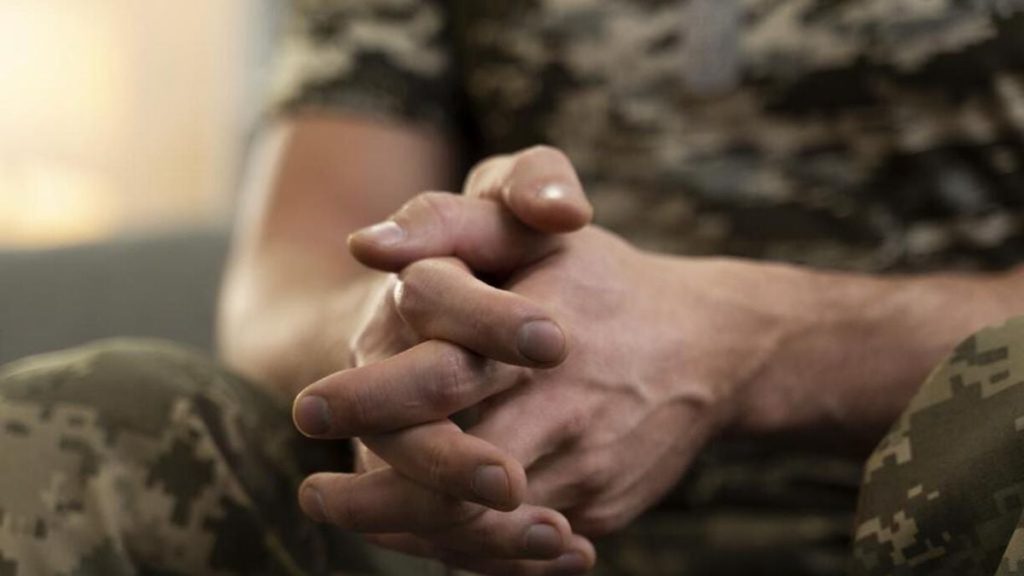 на столі військовий жетон, складений судовий документ і пачка доларів, без людей