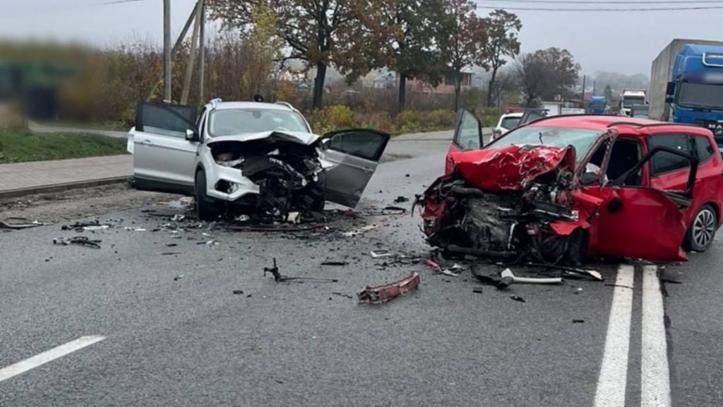 символічна сцена: аварійний автомобіль на сільській дорозі, конус і аптечка на передньому плані, розмиті маячки, без облич