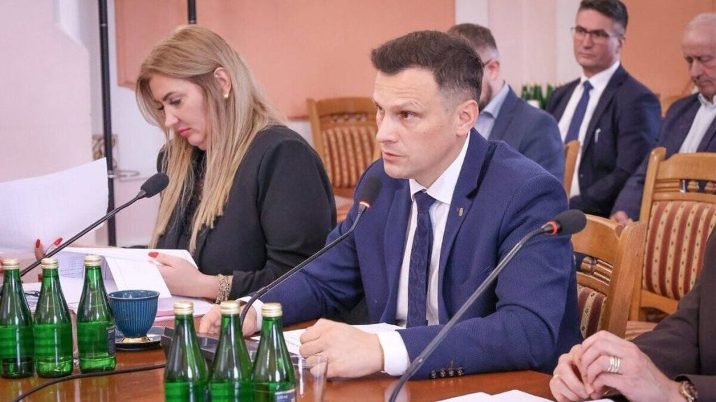 підписаний муніципальний документ поряд зі складеною картою та невеликим прапорцем