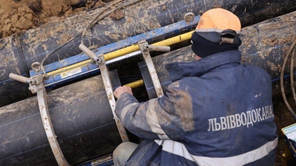 символічна сцена: закритий водопровід, кран без води, відра та складена карта на столі