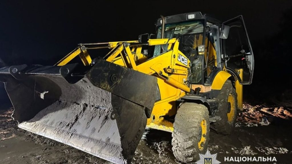 символічна предметна сцена з екскаватором і каскою на гравії, без людей