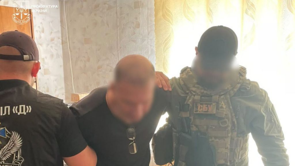 символічне крупне план: наручники на юридичних документах поряд зі складеною картою України
