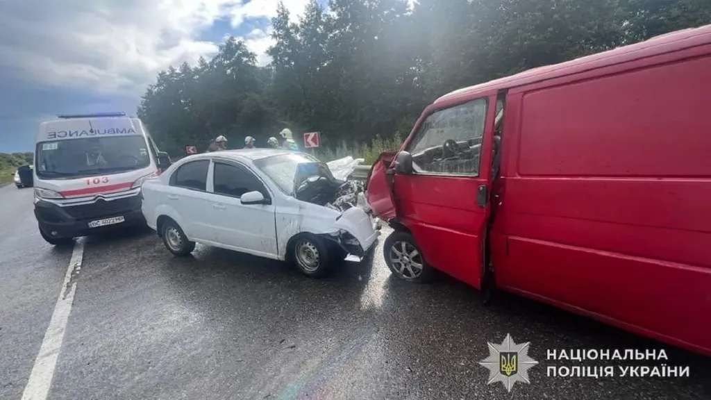 Символічна сцена мокрої узбіччя траси з силуетом пошкодженого авто та конусом, без облич