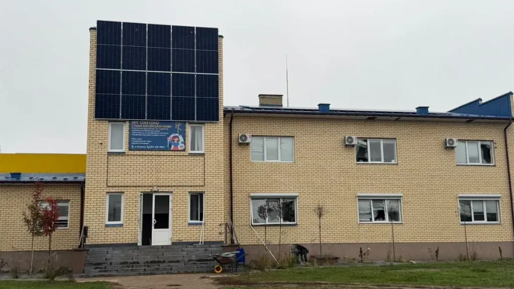 символічне зображення пошкодженої фасаду будівлі з вибитими вікнами і стрічкою екстрених служб, без людей