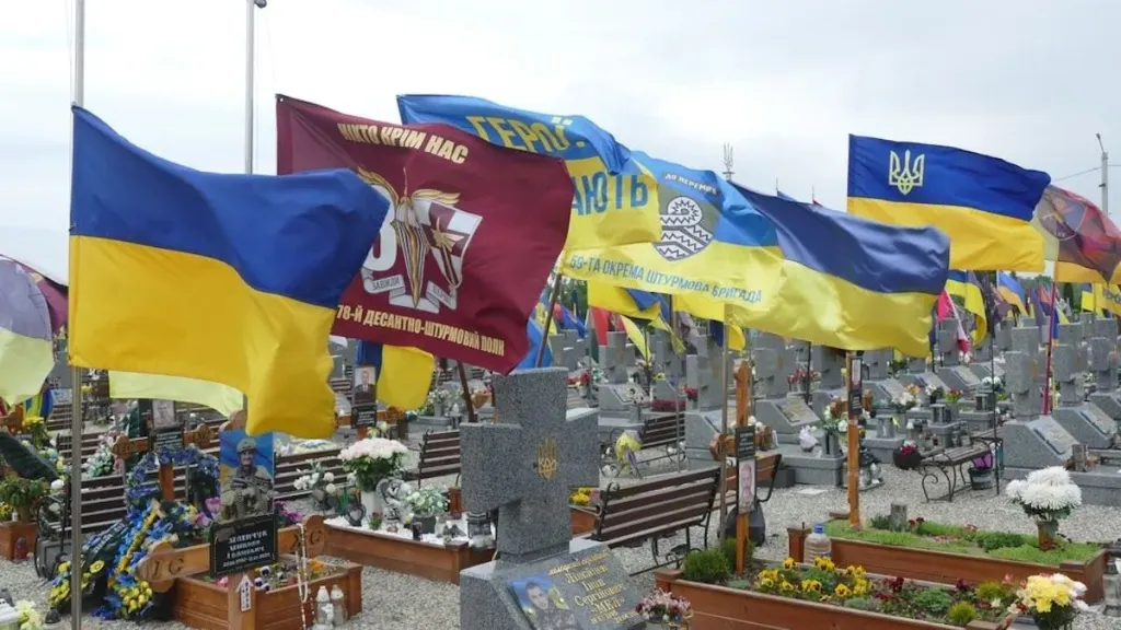 алея кладовища з перевернутими лавками та розкиданими квітами
