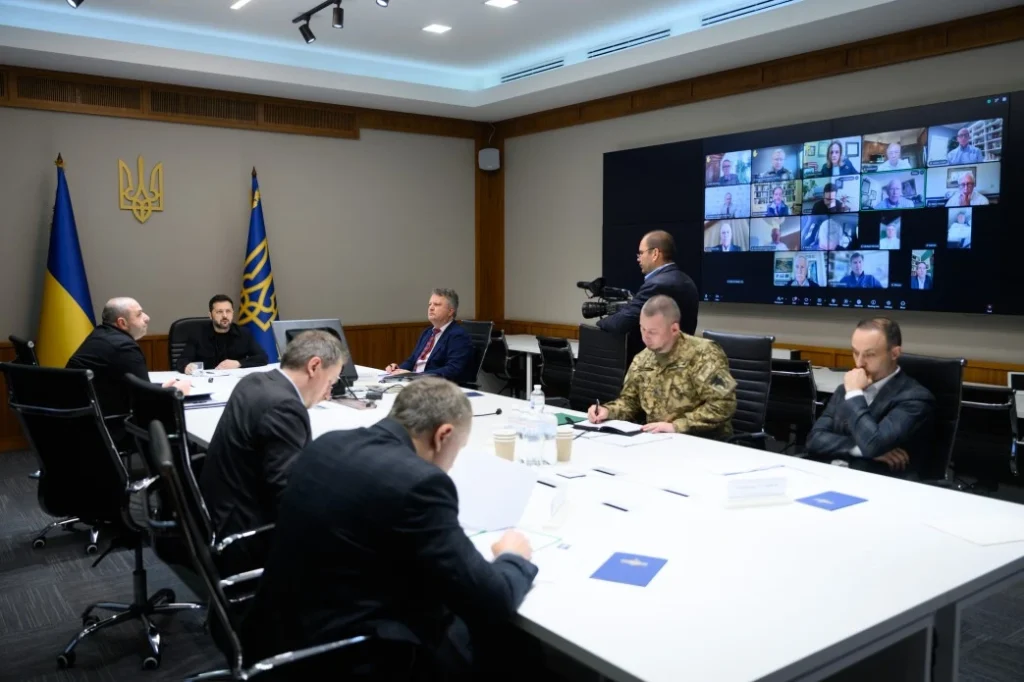 символічна натюрморт-сцена з ноутбуком, прапорцем та картами
