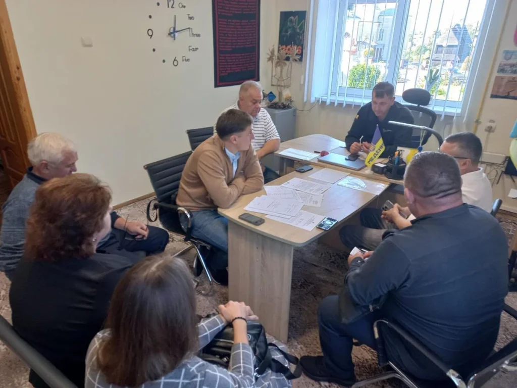 Силует автобуса біля вказівника громади, термінал оплати й GPS-пристрій на столі