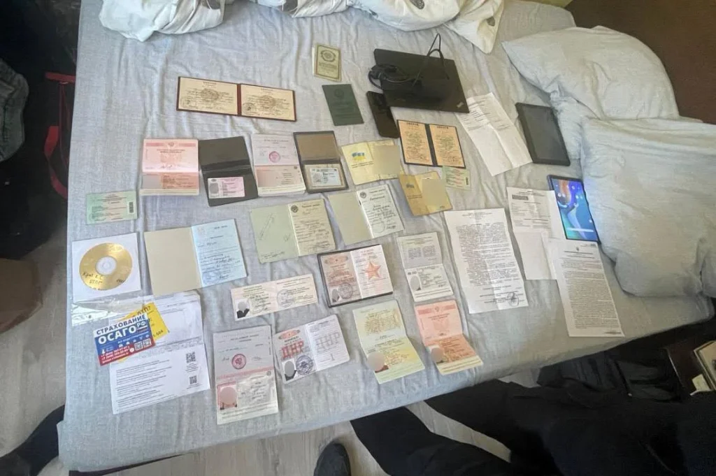 символічна сцена: чемодан, військові квитки та паспорт на столі, без облич