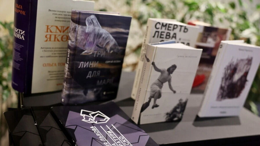 стилізована композиція книг і ручки на деревʼяному столі