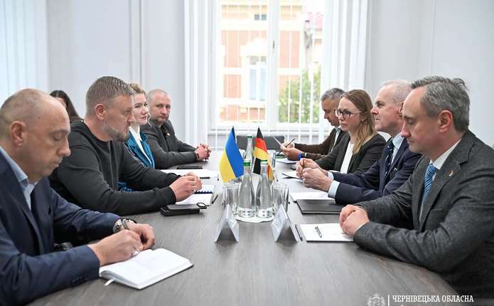 символічна композиція з моделлю заводу, картою України й Німеччини та рукостисканням