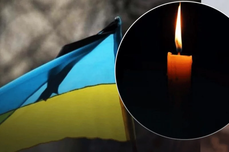 згорнутий прапор, свічка, кулон-адресник і шолом на дерев'яній поверхні