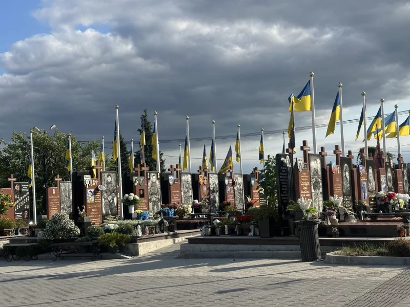 Символічна натюрморт-композиція з прапором, шоломом, жетонами і зів'ялими квітами