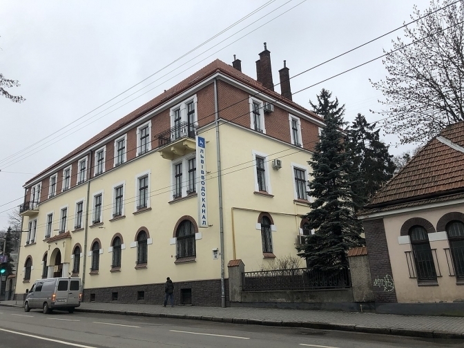 символічна композиція з водолічильником, рукавом, документами та каскою на столі