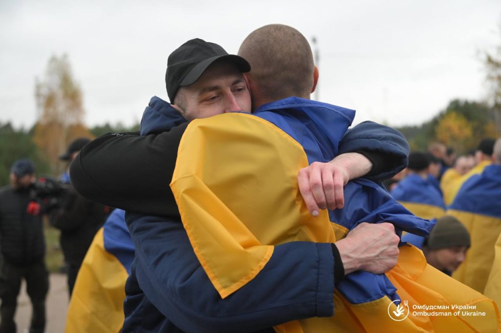 крупний план складеного українського прапора з жетонами і шоломом на дерев'яній поверхні