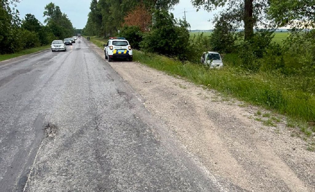 Перевернута іграшкова автівка, водійське посвідчення та бірка на нейтральному фоні