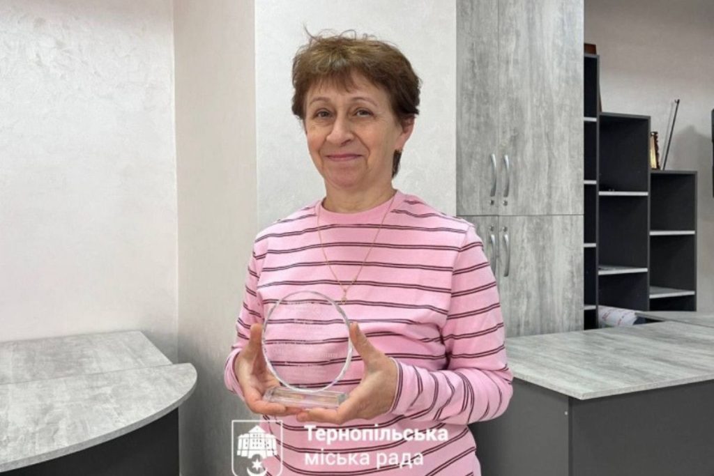 символічна предметна сцена з підручниками, окулярами і конвертом із сертифікатом