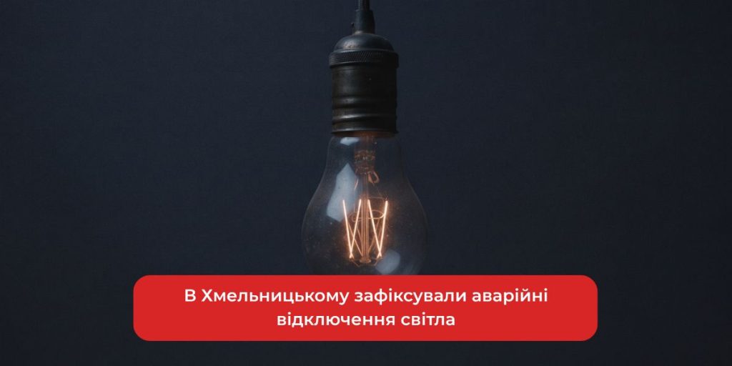 темна вулиця з електроопорою та службовим автомобілем, без людей