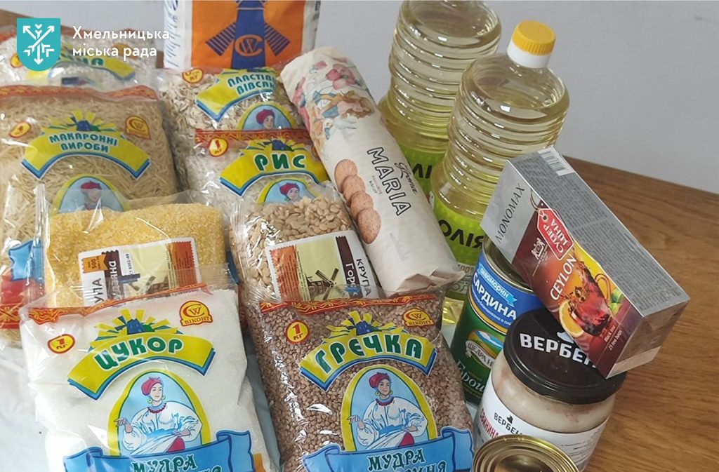 зблизька пакети з продуктами та консерви поруч із брендованим пакетом