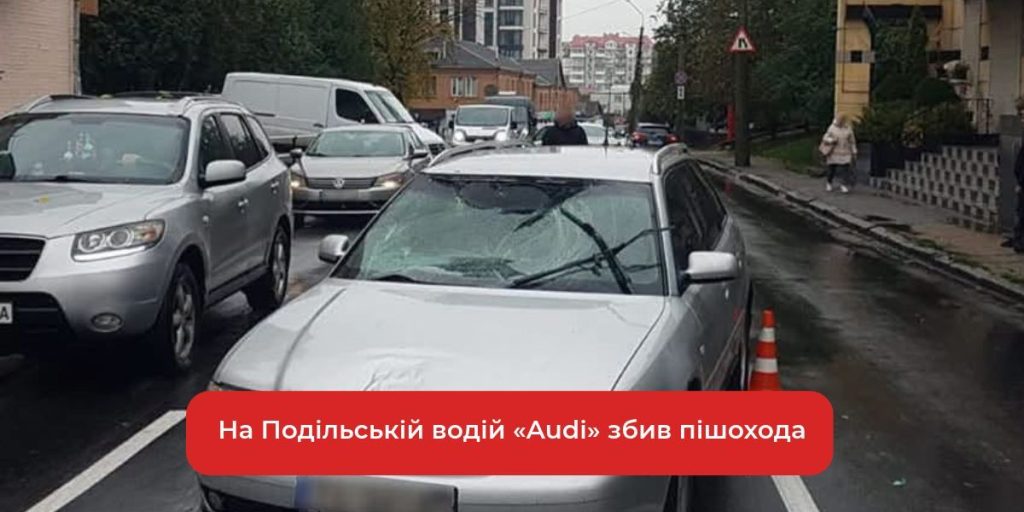 крупний план пошкодженого бампера і одного черевика біля пішохідного переходу, без облич та деталей