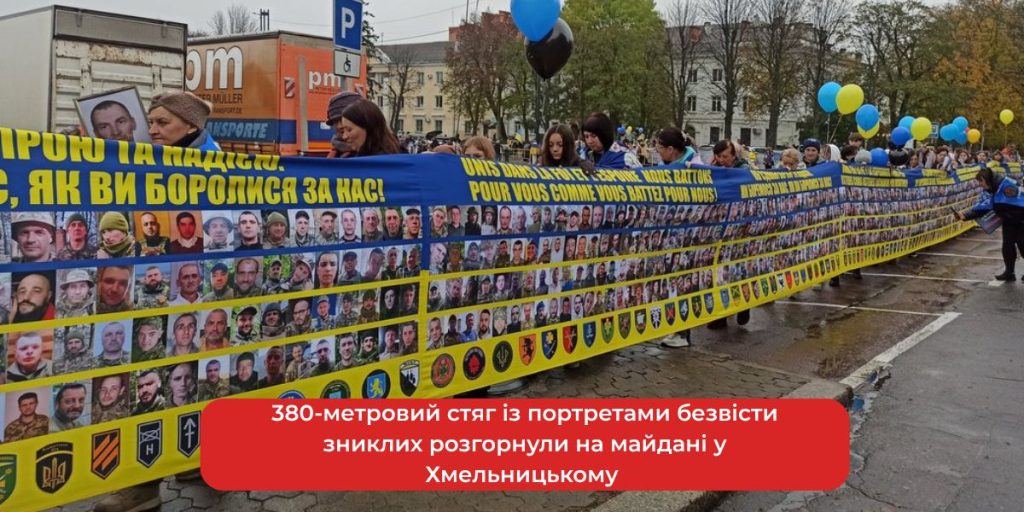 символічний стяг із численними портретами на площі, без впізнаваних облич