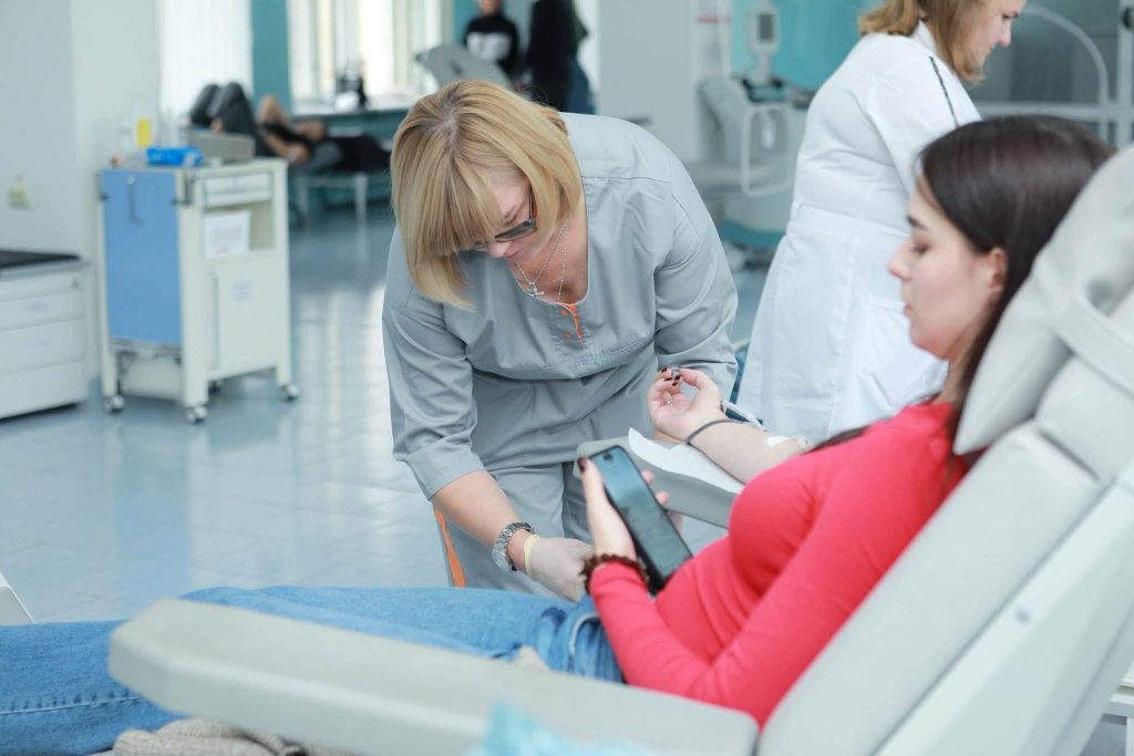 символічна предметна ілюстрація донорства з мішком крові, рукавичками, червоним маком і медичним жетоном
