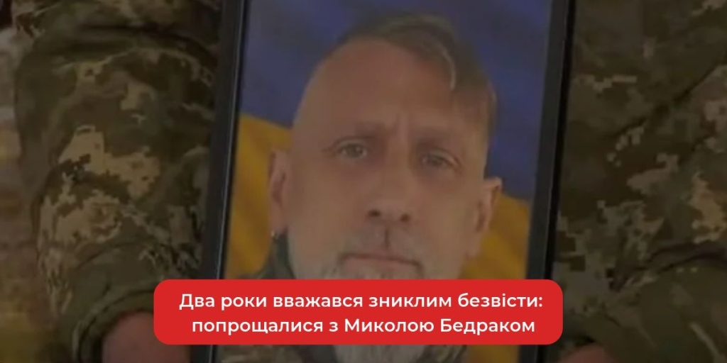 складений мілітарний одяг, шолом і букет польових квітів на столі