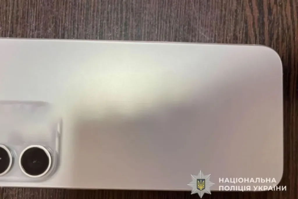 Мобільний телефон на прилавку магазину поруч із дзвіночком і чеками