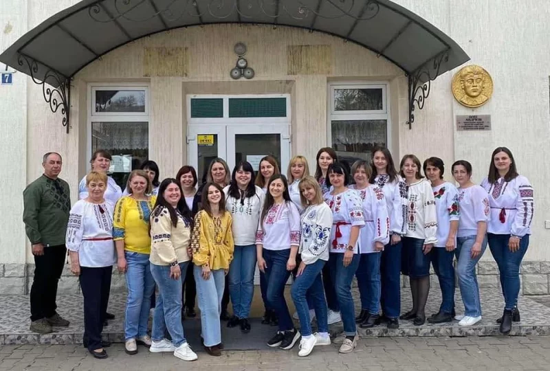 Символічний шкільний стіл із підручниками, українським і румунським прапорцями та порожніми документами