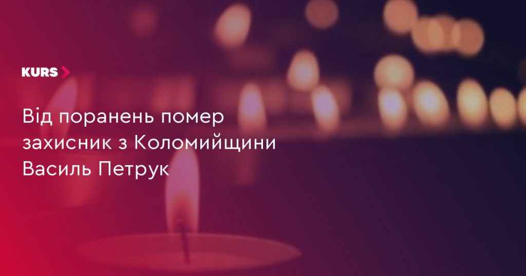 складена військова кашкетка, маленький прапорець України й запалена свічка на дерев'яному столі