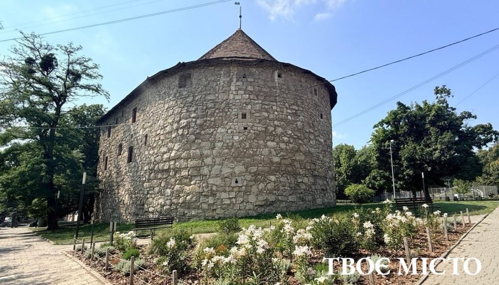 модель Порохової вежі поруч із кресленнями реставрації та інструментами на столі