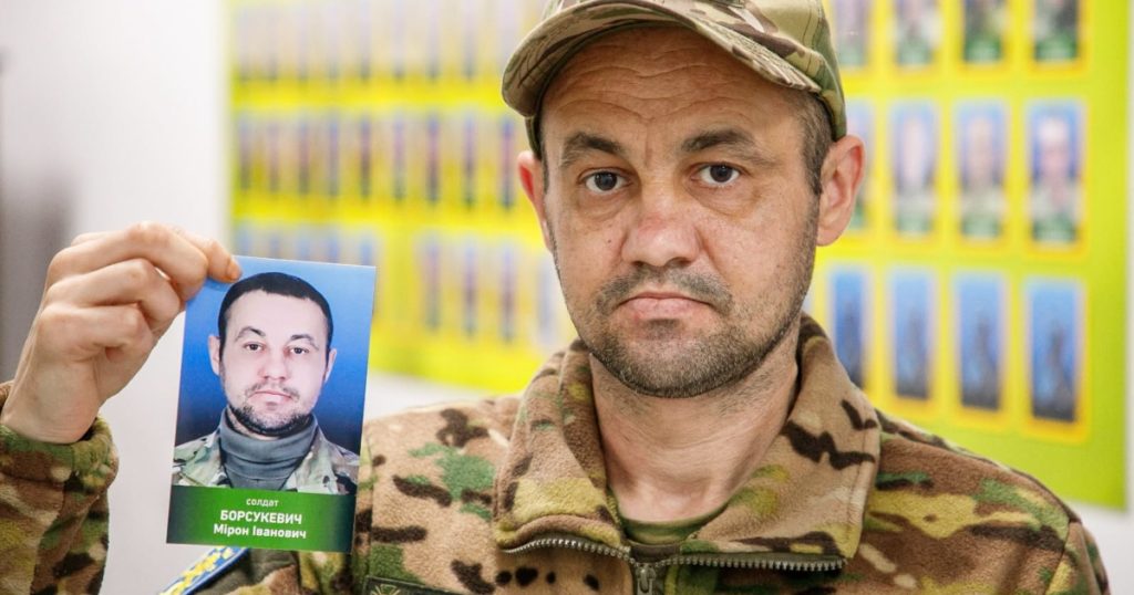 символічна сцена: меморіальна дошка з місцем від знятої фотографії і складеною формою