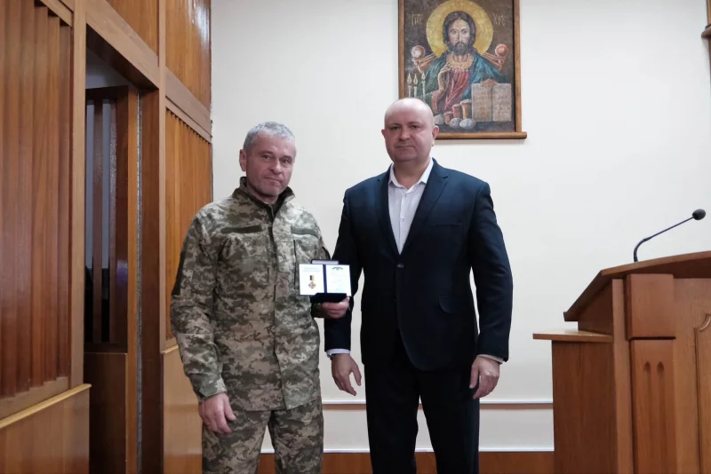 крупний план стрічки медалі поруч із зошитом вчителя та гілкою лавра