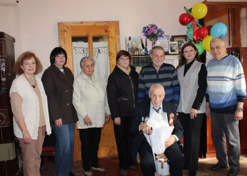 сертифікат, подарунок і букет квітів на дерев’яному столі, м’яке природне світло