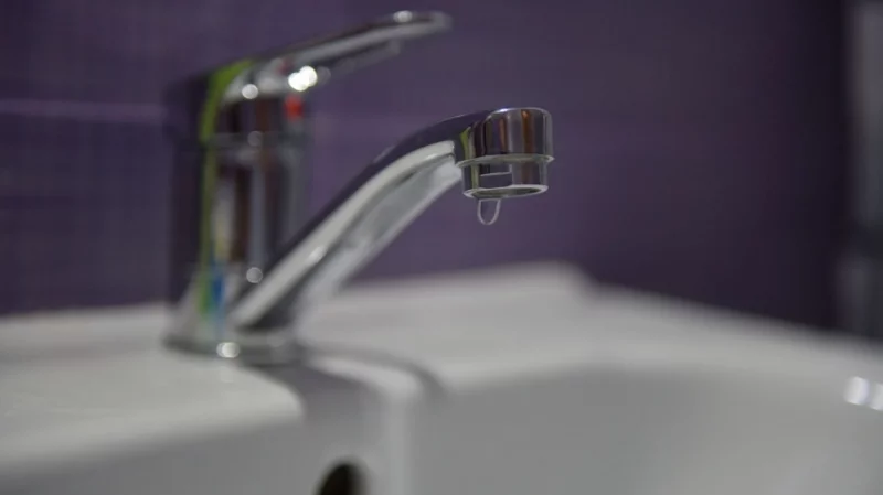 вимірювальний лічильник води, гайковий ключ і конус на тротуарі